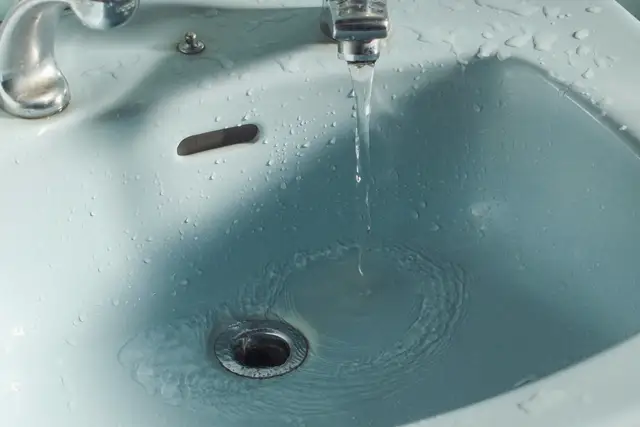 Bathroom basin with water running into the drain