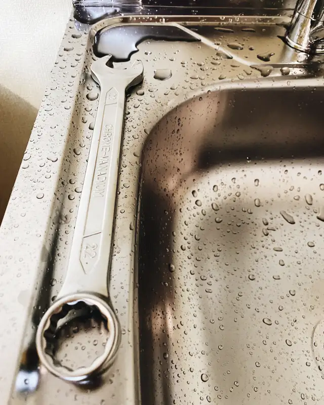 Wrench resting on a stainless sink